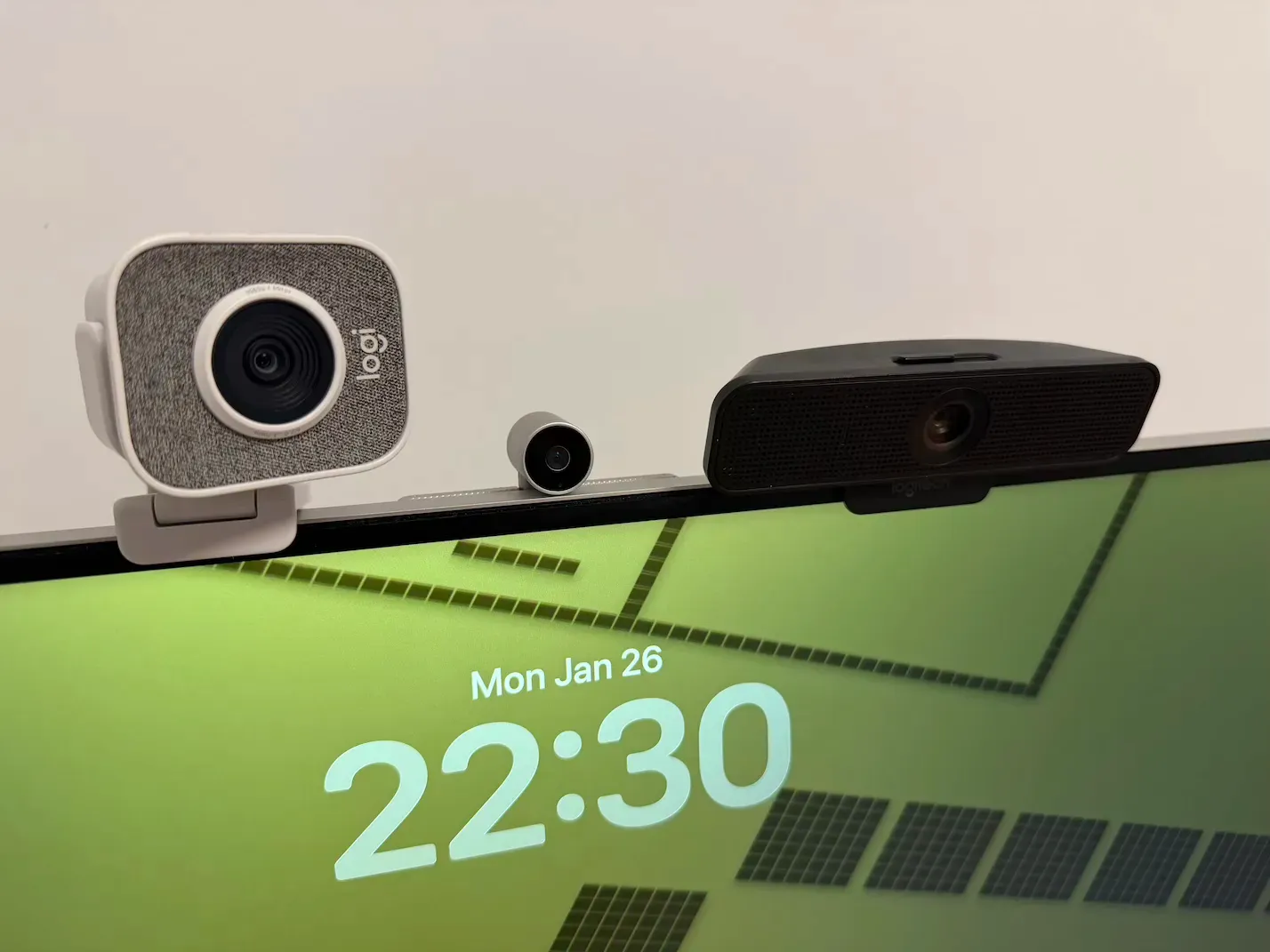 The Logitech StreamCam, Logitech C925e and Samsung SlimFit 4k magnetic webcams standing on a monitor.